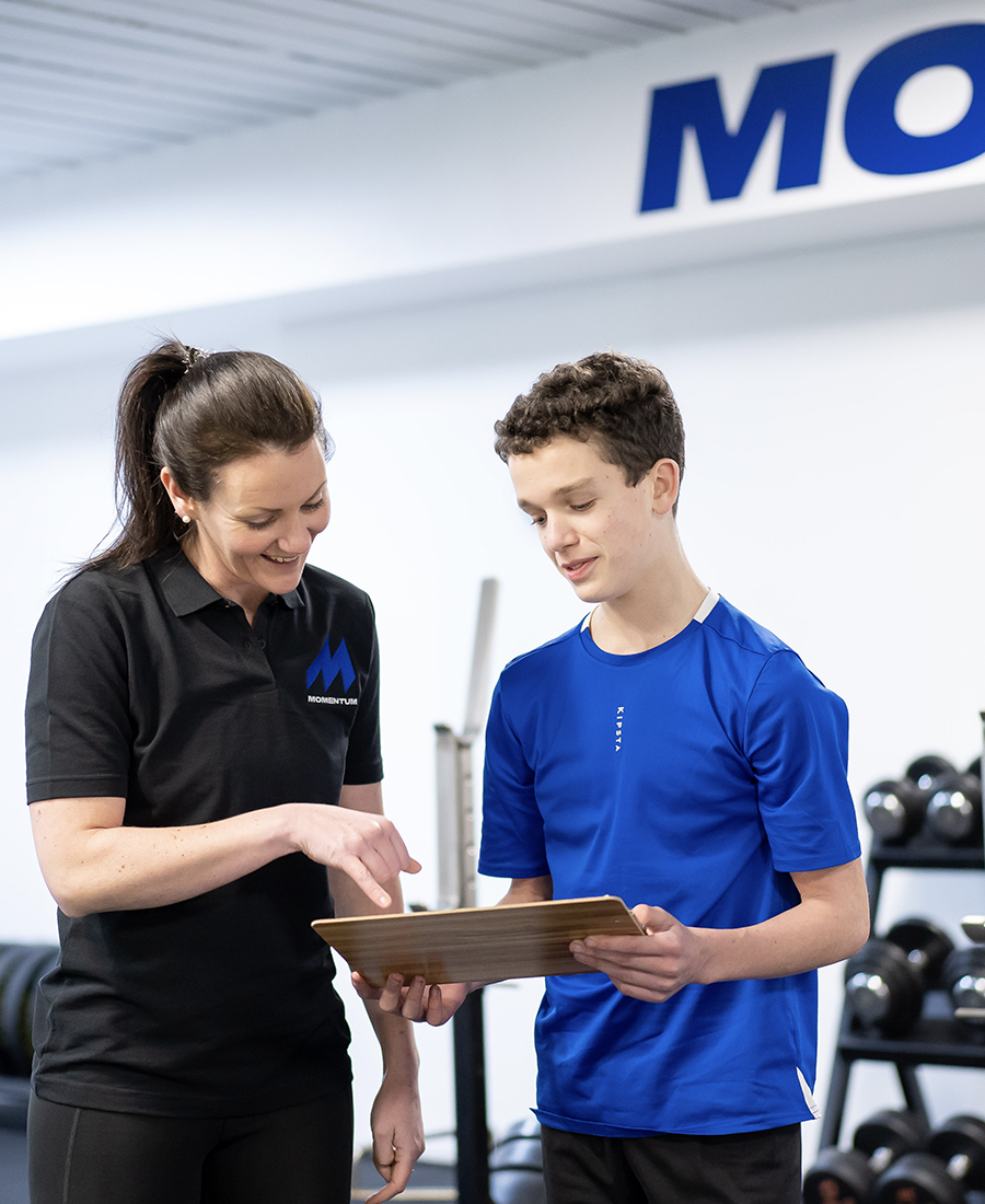 A Momentum staff member helping a young athlete