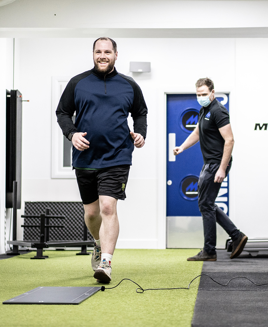 A Momentum staff member helping a client with a footscan